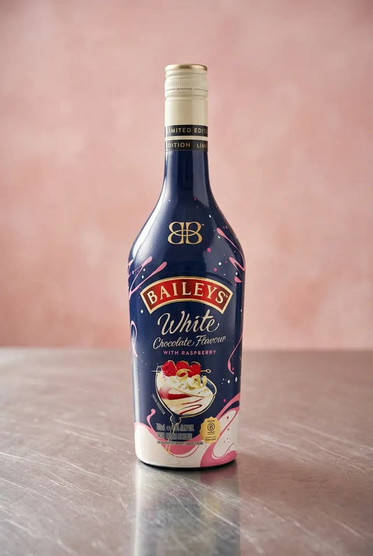 Baileys White Chocolate Raspberry 700ml bottle on a wooden table against a soft pink background